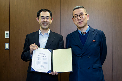 Dr. Adachi (left photo) reports the award with a smile to President, Korea (right photo).