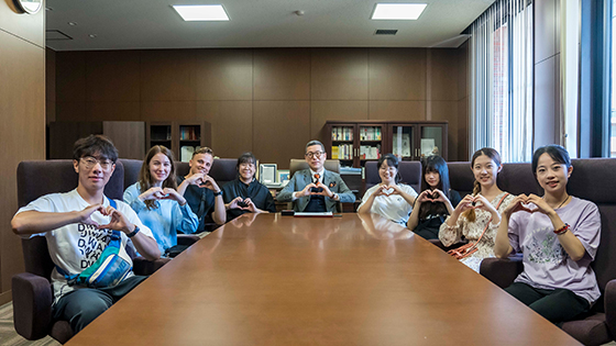 Dr. Adachi (left photo) reports the award with a smile to President, Korea (right photo).